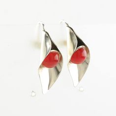 pair of silver and red earrings on white background