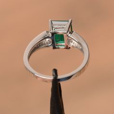 It is a lab emerald ring. The main stone is 7 mm*9 mm emerald cut.weight about 2.06 carats. The basic metal is sterling silver and plated with rhodium. To change the metal to a solid gold (white/rose) or platinum is also available, please ask for a quotation if you want. You can also go to my shop Home for more elegant rings: https://www.etsy.com/shop/godjewelry?ref=hdr_shop_menu Emerald is May birthstone More emerald rings: https://www.etsy.com/shop/godjewelry?ref=seller-platform-mcnav&sect Silver Emerald Cut Anniversary Emerald Ring, Fine Jewelry Emerald Cut Ring For May Birthstone, Fine Jewelry Square Cut Emerald Ring For Anniversary, Fine Jewelry White Gold Emerald Cut Birthstone Ring, Emerald Cut Emerald Ring In White Gold For Anniversary, Fine Jewelry White Gold Birthstone Ring Emerald Cut, White Gold Emerald Cut Emerald Ring For Anniversary, White Gold Emerald Cut Birthstone Ring, Green Emerald Cut Birthstone Ring