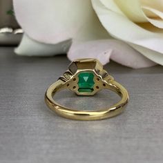 a close up of a ring with a flower in the background