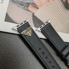 Premium Leather Construction: The Prada Apple Watch replacement strap is made from high-quality leather, ensuring a luxurious feel and long-lasting durability. The leather offers a sophisticated and stylish upgrade to your Apple Watch. Iconic Triangle Monogram Logo: Adorned with Prada's signature triangle monogram logo, the strap showcases the brand's distinctive design and prestigious heritage, adding a touch of elegance to your wrist. Sleek and Elegant Design: The strap features a sleek des... Luxury Black Leather Strap Watch Bands, Luxury Leather Bracelet Strap Apple Watch Band, Luxury Black Watch Bands With Bracelet Strap, Luxury Black Apple Watch Band, Luxury Black Watch Bands, Luxury Black Rectangular Watch Bands, Luxury Leather Strap Apple Watch Band For Business, Luxury Leather Strap Apple Watch Band, Luxury Leather Strap Watch Bands For Business