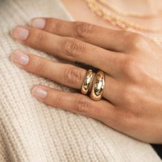 a woman's hand with two rings on it