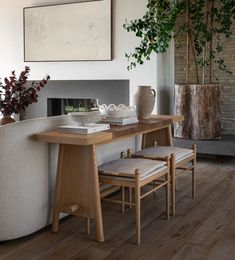 a table with two chairs and a vase sitting on top of it next to a fireplace