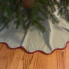 a close up of a christmas tree on a wooden floor with a plaid table cloth