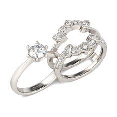 two white gold rings with diamonds on each one and an oval shaped diamond in the middle