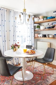 a dining room table with chairs and plates on it