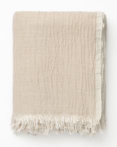 a beige blanket with fringes on it