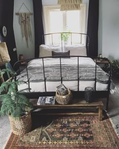 a bed sitting next to a window in a bedroom on top of a wooden table