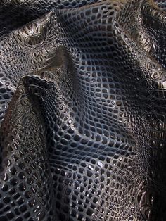 a close up view of a black plastic bag with holes in the mesh and water droplets on it