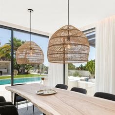 a dining room table with chairs and a large window overlooking the swimming pool in front of it