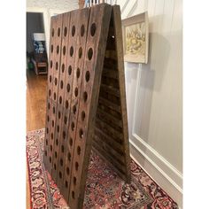 a large wooden board game sitting on top of a rug in front of a stair case