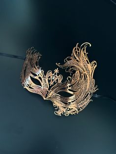 featured is our black metal swan masquerade mask for women. Available in black, rose gold, and gold, each adorned with shimmering crystals, this mask is designed to make you the belle of the ball! Age Group/Gender - Adult/Women Size/Type - One size fits all adults Mask Color - Gold/RoseGold/Black Mask Material - Laser cut metal Gold Fantasy Masquerade Mask For Party, Gold Fantasy Style Masquerade Mask For Party, Gold Venetian Masquerade Mask For Evening, Gold Masks For Evening Carnival, Gold Carnival Masks For Evening, Elegant Gold Mask For Masquerade, Gold Mask For Mardi Gras Evening, Gold Masks For Mardi Gras Evening Events, Gold Masks For Mardi Gras Evening