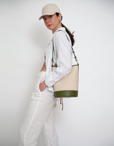 An iconic, leather-trimmed, cotton linen canvas bucket bag • Shoulder Strap Drop: 26- 29"• Crossbody Strap Drop: 40"-47"• Height: 11"• Width: 8"• Depth: 8" • 60% cotton/ 40% linen with 100% genuine leather trim• fully lined• magnetic snap closure• interior zip pocket• adjustable, removable shoulder strap• extra crossbody strap• spot clean Luxury Green Canvas Shoulder Bag, Luxury Green Bucket Bag For Travel, Modern Green Bucket Bag With Leather Handles, Spring Tote Bag With Leather Trim, Spring Bag With Leather Handles And Coated Canvas, Spring Bags With Leather Handles And Coated Canvas, Spring Coated Canvas Crossbody Shoulder Bag, Spring Crossbody Shoulder Bag In Coated Canvas, Spring Travel Bag With Leather Trim