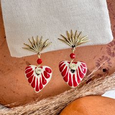 We combine art and elegance to create this beautiful piece. Our handmade earrings will be the perfect element to make your outfit standout. You could have the entire collection or gift them to someone special.  Material: Real Gold plate brass, Talavera gemstone  Dimensions: Drop Length 3cm, weight 2g Features : Lightweight, Unique and Simple design The Talavera of Puebla is part of the intangible heritage of humanity, declared by UNESCO. It is a type of majolica ceramic with a mixture of Chinese, Italian, Spanish, and indigenous techniques, and its colors are obtained from natural pigments. Its main characteristics are its vitreous finish and the use of bulky cobalt blue, this made it even more exclusive and ostentatious than Spanish craftsmanship. Its production requires at least 120 hour Handmade Festive Jewelry For Valentine's Day, Dangle Beaded Brass Earrings For Gifts, Beaded Dangle Brass Earrings For Gifts, Beaded Dangle Earrings In Brass As A Gift, Gift Brass Beaded Dangle Earrings, Gold Drop Earrings With Artistic Design, Red Heart-shaped Earrings For Her, Traditional Red Heart-shaped Jewelry, Gold Earrings For Valentine's Day Celebration