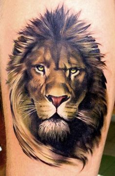 a close up of a tattoo on the leg of a man with a lion's head