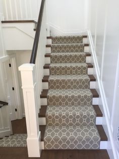 the stairs in this house are decorated with gray and white rugs, which matches the carpet