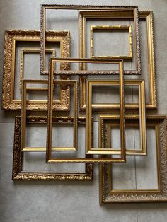 a bunch of gold frames sitting on top of a floor