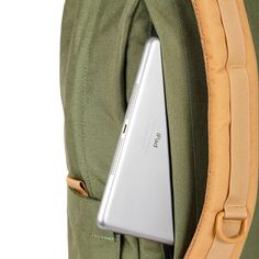 an apple laptop is in the pocket of a backpack