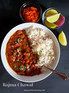 a white plate topped with rice and meat next to a bowl of sauce, lemon wedges and two glasses of orange juice