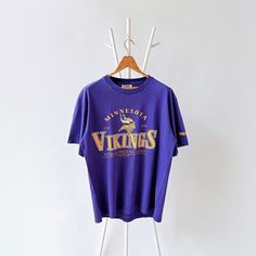 90s Minnesota Vikings NFL t-shirt/ L * PLEASE READ BEFORE PURCHASE * PLEASE consider the PHOTOS before making the decision * The images may DIFFER in appearance from the actual product because we took pictures under daylight.  * PLEASE send your PHONE NUMBER after your purchase for the shipping company to contact you X No returns X No refund Condition : 8/10 More details : look at the pictures  Brand : Lee Size : L Pit to pit/ Chests : 23/46 inches  Length : 29.5 inches  Material : cotton  Color : purple  * ALL ITEMS are VINTAGE which may show some signs of wear and tear * Due to the different display and different light, the picture may not reflect the actual color of the item * Please, remember that our items are vintage so they may show some signs of wear, tear and yellow stains. Thank Nfl T Shirts, Shipping Company, Minnesota Vikings, Phone Number, Minnesota, Vikings, Nfl, Thailand, Bathing Beauties