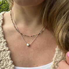 This simple circle charm necklace is the perfect minimalist every day jewelry. The elegant sterling silver dot charm floats on a sterling silver bead chain for a great feminine classy look. Sterling Silver Focal Bead - 6mm Choose your length at checkout! Model is wearing 18 inches Jasper Necklace as shown in photos: https://www.etsy.com/listing/1471325157/layering-necklace-fancy-jasper-beaded?click_key=e2a7461b0b24e4766d5ab61279a7dbfaeb15f0e2%3A1471325157&click_sum=26b804b0&ref=shop_home_active_1&pro=1&frs=1 To view more of my original jewelry designs, visit: https://www.etsy.com/shop/TheBeadCounter Sterling Silver Charm Necklaces For Layering, Sterling Silver Round Charm Necklaces For Layering, Minimalist Round Bead Charm Necklace As Gift, Sterling Silver Charm Necklaces With Round Beads, Silver Charm Necklace With Round Pendant And Satellite Chain, Minimalist Double Strand Charm Necklace, Silver Charm Necklace With Satellite Chain, Silver Dainty Charm Necklace For Layering, Minimalist Silver Beads Round Jewelry