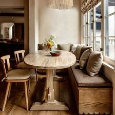 a wooden table sitting next to a window in a living room under a light fixture