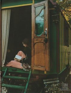 an old black and white photo of a woman sitting in the doorway of a train car