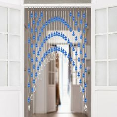 an open door with blue beads hanging from it's sides and a white wall in the background