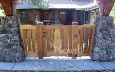 a wooden gate with stone pillars and posts in front of a brick house that has the word rowe written on it