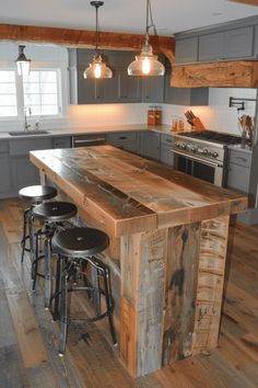 a kitchen with an island made out of wooden planks and metal barstools