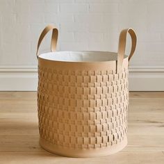 an empty basket sitting on top of a wooden floor