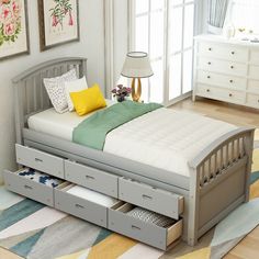 a bed with drawers underneath it in a room