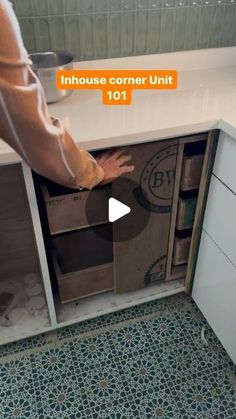 a man is opening the drawers in his kitchen with an orange sticker on it