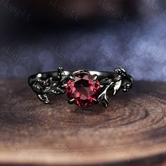 a red stone ring sitting on top of a wooden table