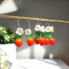 The vibrant red hue and realistic strawberry design make them a standout accessory, while the lightweight construction ensures all-day comfort.  🍓Material: handmade with resin strawberries, resin flowers, hand drawn leaves and 925 silver/14K gold plated ear hooks which are hypoallergenic.  🌺Size: The single strawberry earrings (W x L) are about 2cm x 5cm. The duo strawberry earrings (W x L) are about 2.5cm x 5cm. 🎁Packaging: Our jewelry will be individually inspected before shipping. The jewe Cute Red Earrings With Fruit Design, Red Fruit Design Drop Earrings, Cute Red Strawberry Print Earrings, Trendy Red Flower-shaped Earrings, Trendy Red Jewelry With Fruit Design, Trendy Red Fruit Design Jewelry, Earrings Strawberry, Drawn Leaves, Strawberry Earrings