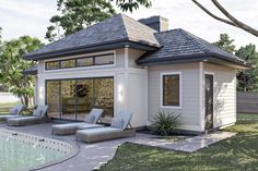 a pool house with lounge chairs around it