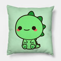 a green pillow with an image of a cute little monster on it's back