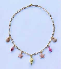 Introducing the stunning Pink Shell Charm Necklace, the cutest blend of coastal elegance and summer charm!  This enchanting necklace is the epitome of seaside dreams, featuring a beautiful gold conch shell charm at its center, surrounded by adorable pink starfish, delicate conch shells, and dainty clam shell charms. Each charm is a tiny piece of the beach you can wear wherever you go, adding a touch of coastal magic to your outfits. Handmade with love and bursting with personality, this necklace is the perfect accessory for beach babes. It's the ideal way to add a pop of color and coastal elegance to any outfit, whether you're hitting the beach or looking to brighten up any look.  Wear it with your favorite summer sundress dress for a laid-back, beachy vibe, or layer it with other necklace Handmade Pink Jewelry For Beach Party, Pink Jewelry For Beach Party, Pink Jewelry For Beach Party Season, Bohemian Pink Jewelry For Beach Party, Summer Beach Dangle Jewelry, Beach Season Party Beachy Necklace, Beach Jewelry With Charms, Beach Charms Jewelry, Beachy Shell Necklace With Starfish Charm For Vacation