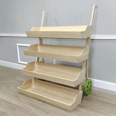 a three tiered wooden shelf sitting on top of a hard wood floor next to a wall