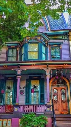 an old victorian house painted in purple and blue with lots of green shutters on the front