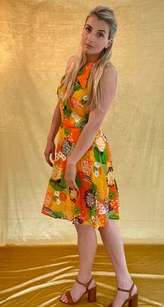 A Bright orange/yellow/green 60s printed chiffon sleeveless dress. The ideal festival/wedding halter neck dress. It's Shown on a Medium sized model. Chest measures 35 inches and total length is 36 inches. In good vintage condition. Retro Halter Neck Summer Dress, Fitted Yellow Dress With Retro Print, Yellow Spring Dress With Retro Print, Yellow Dress With Retro Print For Spring, Orange Retro Print Summer Dress, Mod Summer Beach Dresses, Summer Mod Beach Dresses, Fitted Retro Sleeveless Halter Dress, Orange Mod Dress With Retro Print