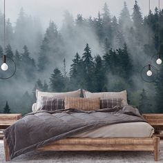 a large bed sitting in front of a forest wall mural