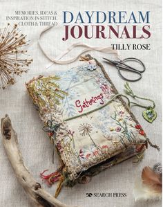 the cover of daydream journals, featuring an old book with embroidered pages and thread