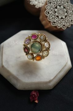 Skillfully made using classic methods, the ring features a fragile design embellished with semi-precious navrattan gemstones and the radiance of multicolored stones. These stones impart a touch of sophistication to this timeless treasure. Enhance your fashion with this exceptional ring. Closure - Adjustable Weight- 17gms Handcrafted in Jammu and Kashmir Paisley Pop travels the depths of India to learn techniques and crafts from deep down in the local markets and villages. We give utmost importance to our quality and packaging. Our goal is to ensure you receive exactly what you are looking for and for your experience to be special and memorable. We are ready to help and advise you through your purchase. IT' S  A W E S O M E * Our lovely packaging is designed by our co-founder Tanya. And all Luxury Elegant Meenakari Rings, Luxury Crystal Ring With Gemstone Accents For Wedding, Luxury Emerald Ring With Gemstone Accents For Wedding, Heirloom Multicolor Jewelry With Accent Stones, Luxury Handmade Pearl Ring For Wedding, Elegant Multicolor Open Crystal Ring, Elegant Multicolor Ruby Ring, Multicolor Oval Heirloom Ring, Heirloom Multicolor Ring Jewelry