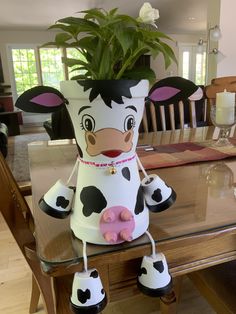 a cow planter sitting on top of a glass table