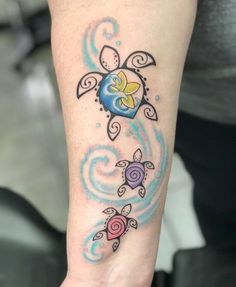 a woman's arm with a tattoo on it that has an image of a turtle and flowers