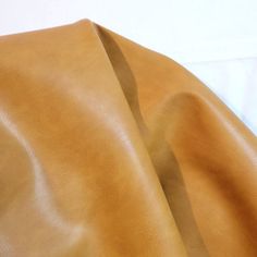 a close up view of a tan leather material with some folds on the top and bottom