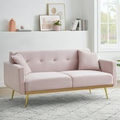 a pink couch sitting on top of a white rug