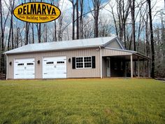 a two car garage sits in the middle of a field with trees and grass around it