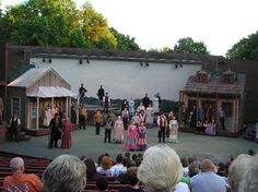 a group of people standing on top of a stage next to each other in front of an audience