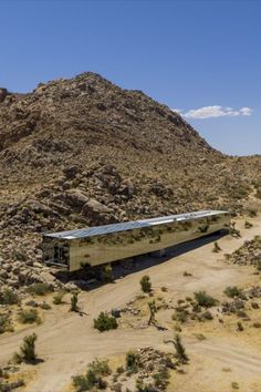 a train traveling through the desert with mountains in the background